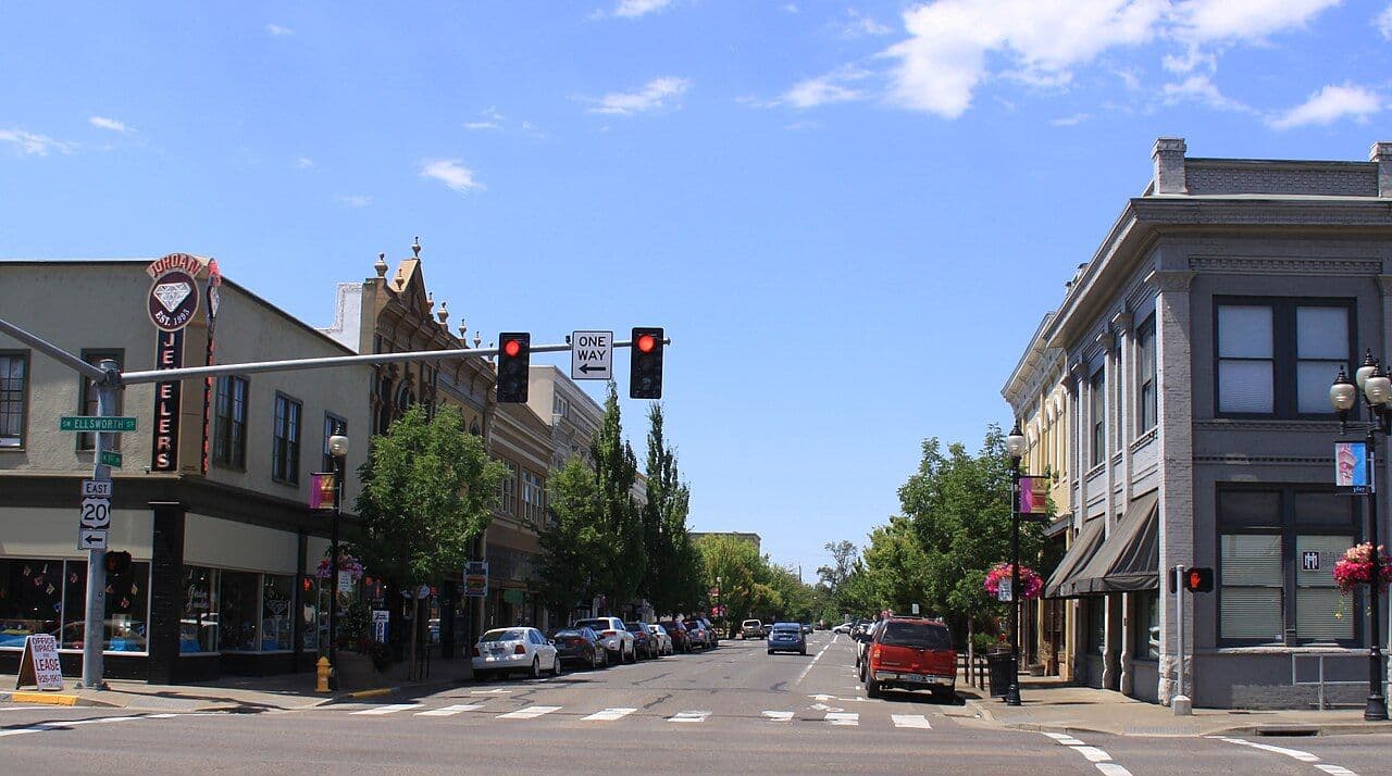 First Avenue in downtown Albany, looking west past historic brick storefronts on a summer day.